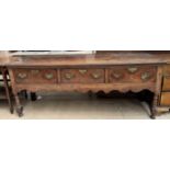 An 18th century oak dresser base with a planked rectangular top above three drawers,
