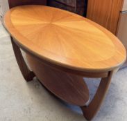 A Nathan teak coffee table with a sunburst oval top with an undertier