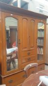 An Edwardian satin walnut triple wardrobe, with a moulded cornice above mirrored doors,