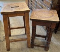 An elm seated stool with handle inset to the centre together with another stool with a dished