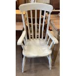 A white painted slat back kitchen elbow chair with a solid seat on turned legs and stretchers