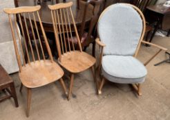 A pair of Ercol stick back dining chairs together with a rocking chair
