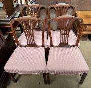 A set of four George III mahogany dining chairs with shaped backs and vase splats above pad seats
