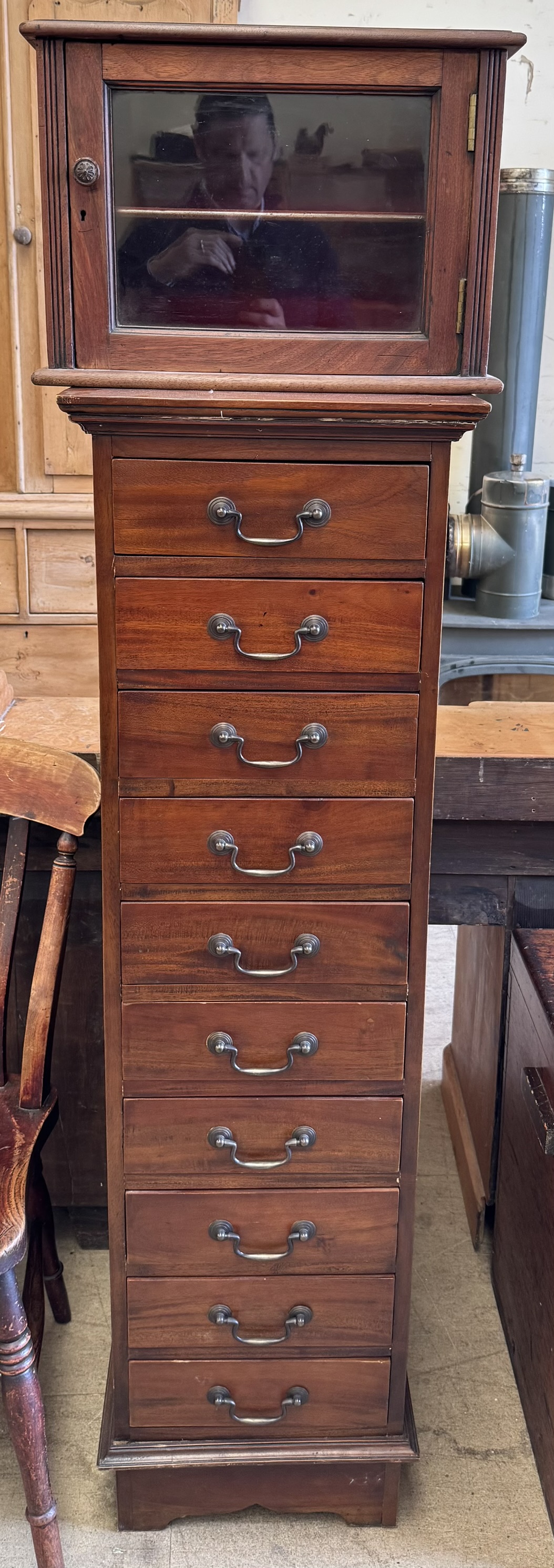 A reproduction chest with ten drawers on bracket feet together with a table top glazed cabinet