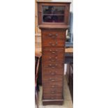 A reproduction chest with ten drawers on bracket feet together with a table top glazed cabinet