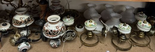 A set of five pottery and brass wall lights with opaque glass shades together with a brass