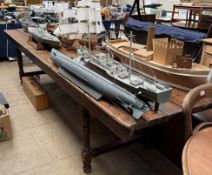 A large pine refectory table with a planked top on a folding base,