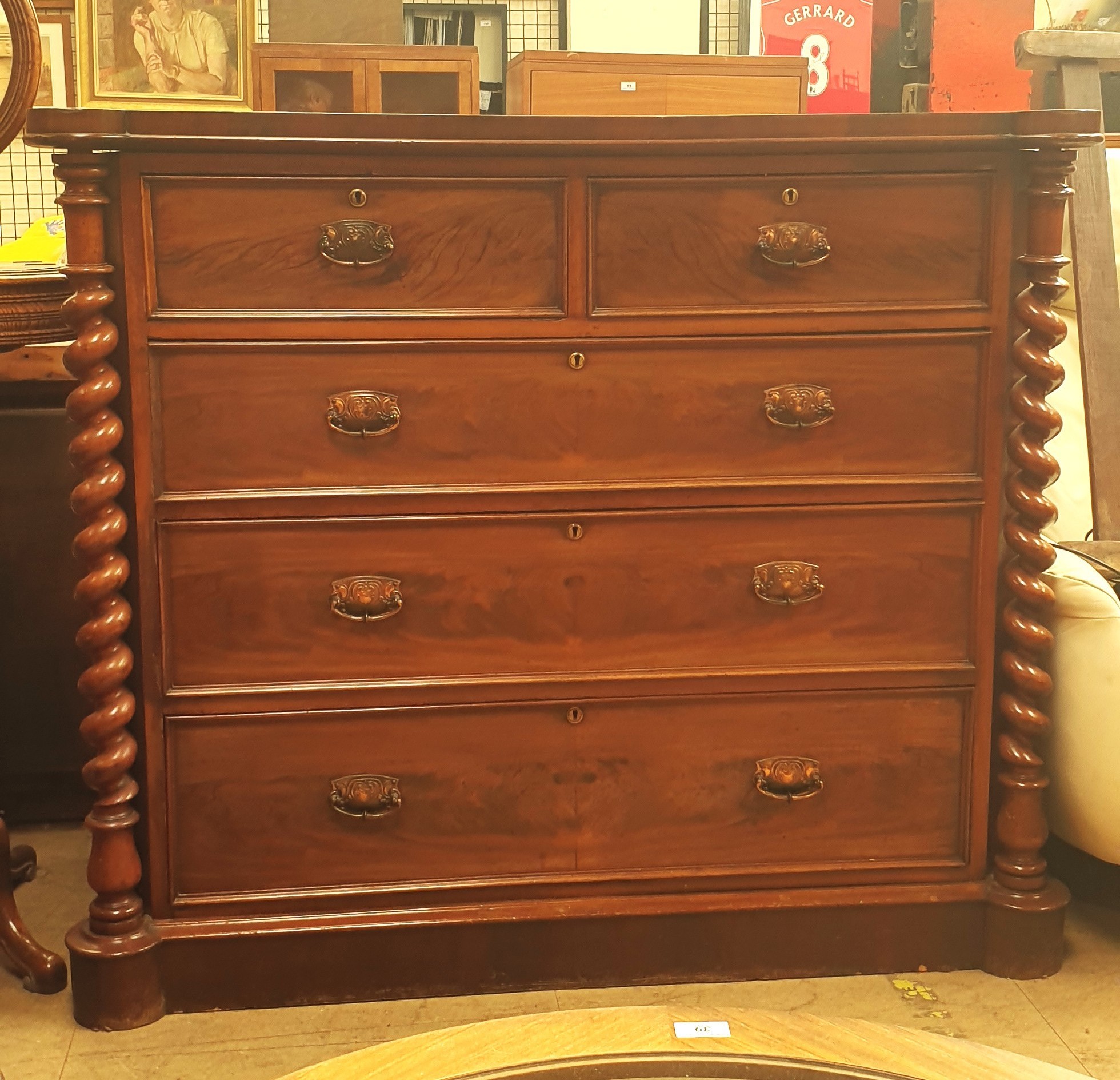 A Victorian mahogany chest with two short and three long drawers enclosed between rope twist