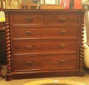 A Victorian mahogany chest with two short and three long drawers enclosed between rope twist