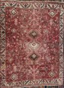 A red ground rug with three medallions, with stylised animals and trees,