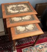 A nest of three teak tiled top tables