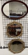 Two gilt framed wall mirrors of circular form together with an oval wall mirror