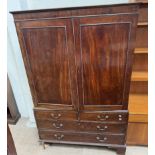 A 19th century mahogany linen press with a moulded cornice above a pair of cupboard doors and linen