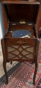 An oak gramophone cabinet with a hinged lid on shaped legs