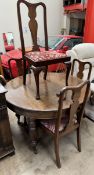 An early 20th century oak extending dining table of circular form with an additional leaf together