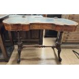 A Victorian walnut lady's writing desk with a shaped top with a central pen well,