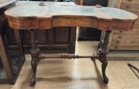 A Victorian walnut lady's writing desk with a shaped top with a central pen well,