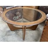 A G-Plan Astro teak coffee table of circular form with an inset glass top on shaped legs,