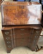 A 20th century mahogany bureau with a sloping fall and fitted interior above four drawers on