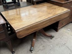 A 19th century mahogany sofa table with drop flaps and a frieze drawer on a turned column and four
