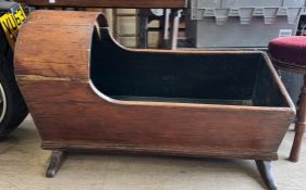 A 19th century child's cot with a domed canopy with solid sides on a rocker base
