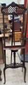 A mahogany easel with an open fretwork arched top ,a single shelf on splayed legs,