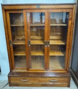 A satin walnut display cabinet with three sliding doors and two drawers on a plinth base, 127.