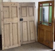 A pair of pine doors together with a pine and glazed door with coloured panels