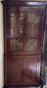 A 19th century mahogany corner cabinet with a moulded cornice above a pair of glazed doors,