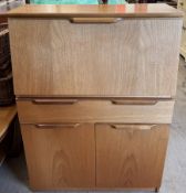 A Uniflex teak bureau with a drop flap and fitted interior above two drawers and two cupboards