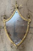A gilt decorated shield shaped wall mirror with shell decoration,