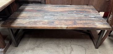 A rustic coffee table, with a planked top on a metal base,