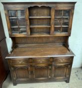 A 20th century oak dresser with glazed and shelved top,