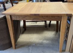 A 20th century oak extending dining table on square tapering legs