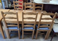 A modern kitchen extending dining table and six ladder back chairs