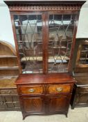 A George III mahogany secretaire bookcase with a moulded cornice above a pair of glazed doors,
