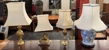 A gilt metal table lamp in the form of a cherub riding a swan together with three other table lamps