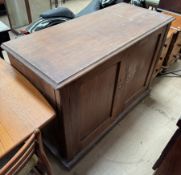 A pine side cabinet with a rectangular moulded top above a pair of cupboard doors on a plinth,