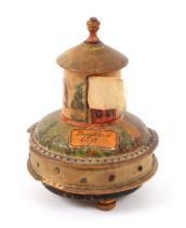A whitewood paint and label decorated combination tape measure / pin cushion, raised on three turned