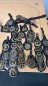 Collection of vintage brass horse brasses on leather harness straps, featuring various heraldic,