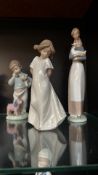 Set of three Nao by Lladró porcelain figurines, made in Spain. They feature a glossy finish and