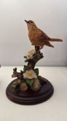 Three decorative resin bird figurines on wooden bases