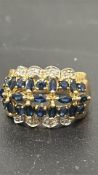 9ct Gold ring featuring an intricate design with blue sapphires and sparkling diamonds. Size N.5