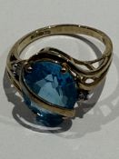 9ct gold ring set with large blue topaz and two di