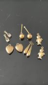 Collection of yellow metal charms, pendants & earr
