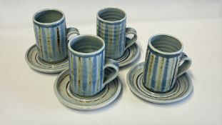 Set of four studio pottery striped stoneware mugs and saucers