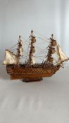 Wooden model of a three-masted fully rigged ship on plinth stand, with cotton sails and detailed