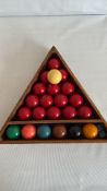 Set of 22 snooker balls—15 reds, 6 coloured, and white cue—together with wooden triangular rack