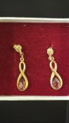 Yellow metal earrings set with rubies