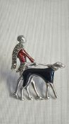 Art Deco-style silver-tone brooch modelled as a 1920s lady walking a greyhound, accented with